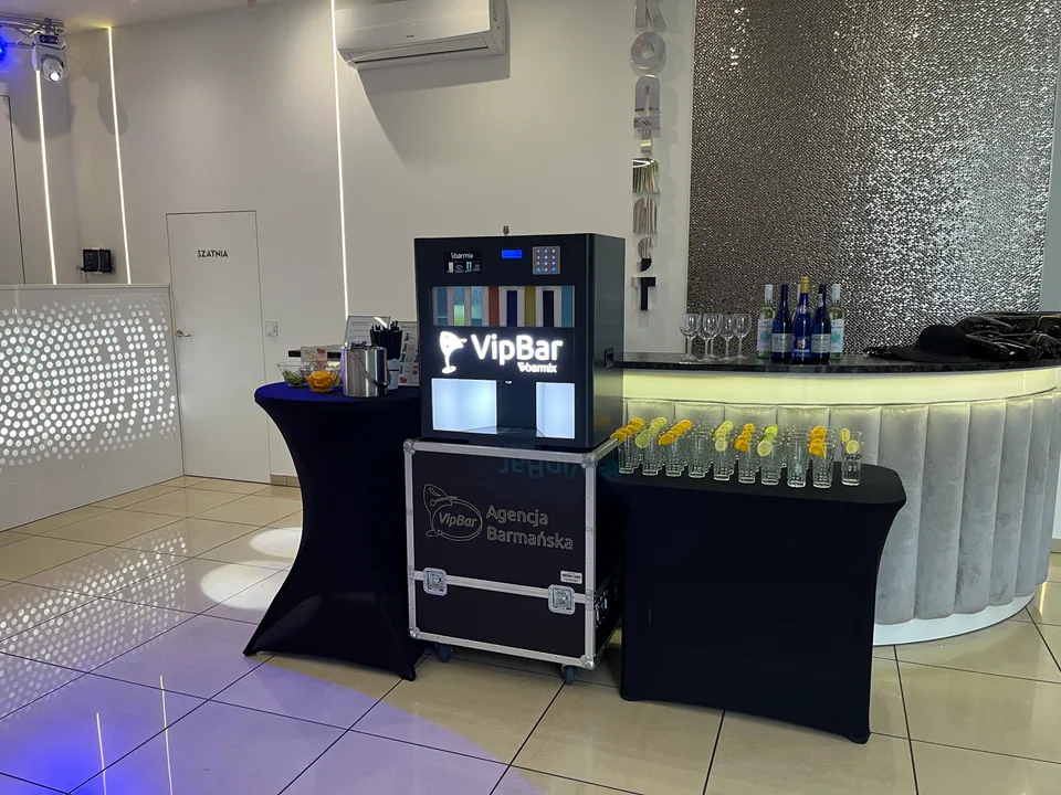 Automatyczny barman ze szklankami na czarnych stolikach przy białej ladzie
