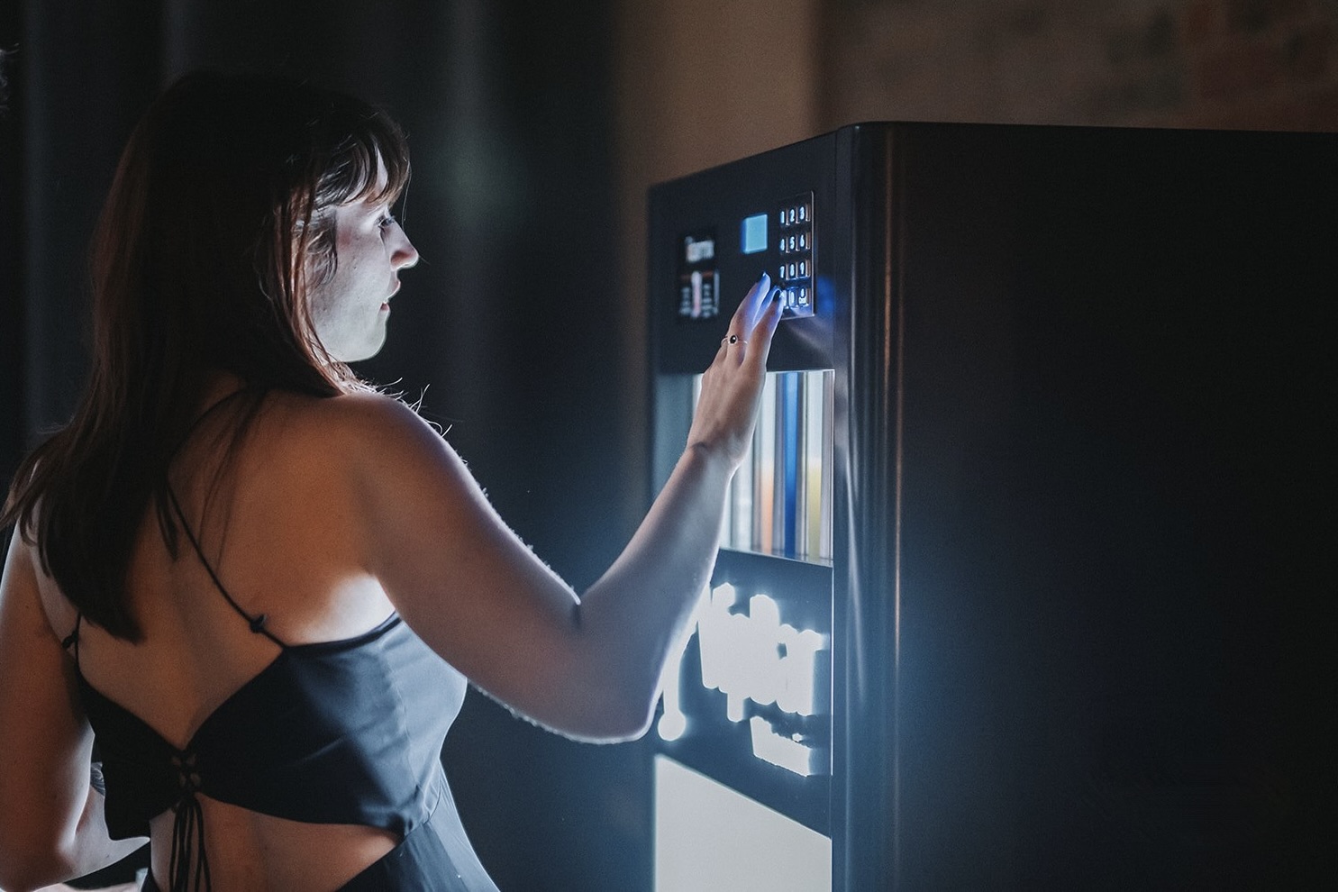 Gość wybierający drinka na panelu automatycznego barmana